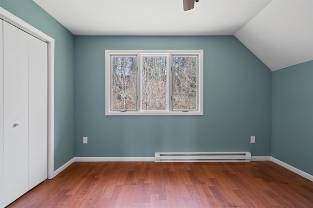242 Callicoon Center Rd, Jeffersonville, NY 12748 - unfurnished bedroom with lofted ceiling, baseboard heating, baseboards, a closet, and wood finished floors