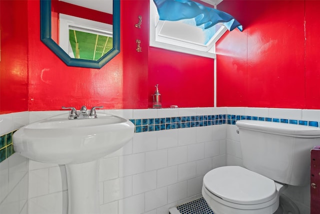 242 Callicoon Center Rd, Jeffersonville, NY 12748 - half bathroom featuring toilet, a wainscoted wall, tile walls, and plenty of natural light