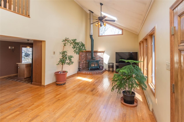 295 Overhill Rd, Stormville, NY 12582 - living room with hardwood / wood-style floors, a ceiling fan, a wood stove, and a healthy amount of sunlight
