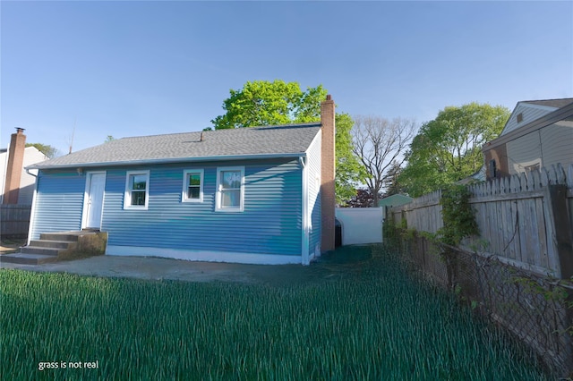 23 Cumberbach St, Wyandanch, NY 11798 - rear view of property featuring a fenced backyard, a chimney, and a yard