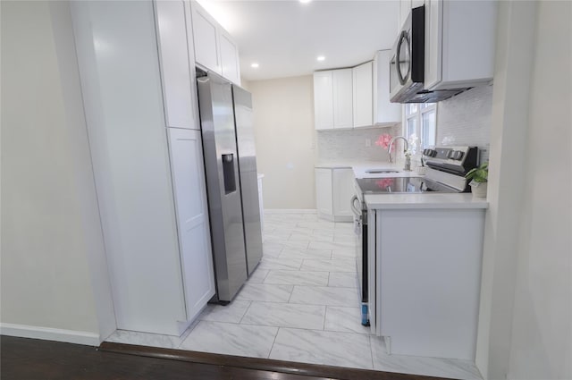 23 Cumberbach St, Wyandanch, NY 11798 - kitchen featuring decorative backsplash, appliances with stainless steel finishes, a sink, light countertops, and white cabinetry