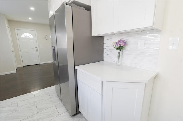 23 Cumberbach St, Wyandanch, NY 11798 - kitchen with light countertops, white cabinets, stainless steel fridge, and tasteful backsplash