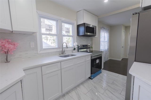 23 Cumberbach St, Wyandanch, NY 11798 - kitchen with white cabinets, stainless steel appliances, a sink, and backsplash