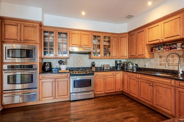 kitchen featuring under cabinet range hood, visible vents, a sink, a warming drawer, and appliances with stainless steel finishes