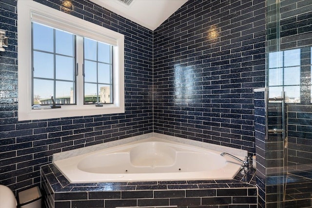 bathroom with a whirlpool tub and vaulted ceiling