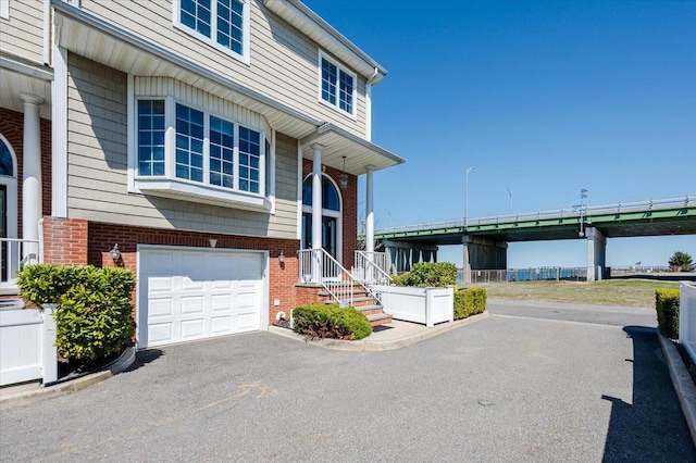 view of front facade with brick siding and a garage