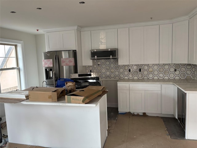 67 2nd St W, Mount Vernon, NY 10550 - kitchen with white cabinets, tasteful backsplash, appliances with stainless steel finishes, and a center island