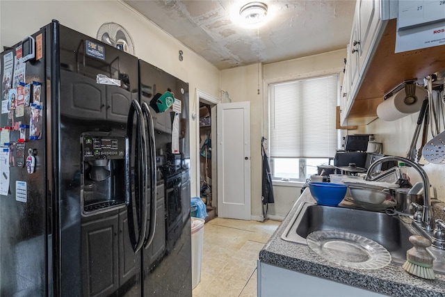 1816 21st Dr, Astoria, NY 11105 - kitchen featuring black refrigerator with ice dispenser, dark countertops, light floors, and a sink