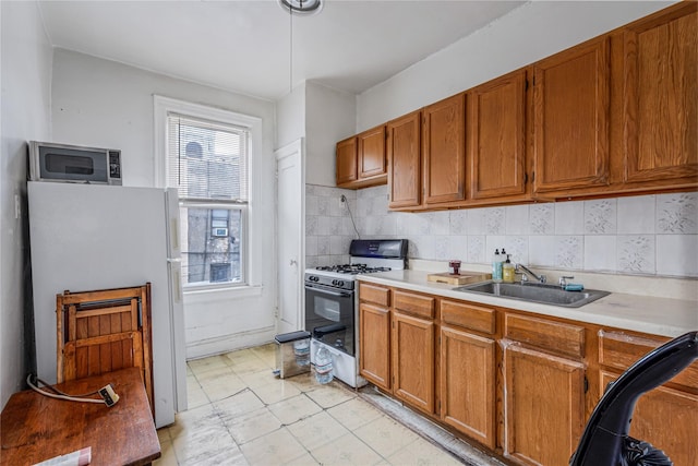 1816 21st Dr, Astoria, NY 11105 - kitchen featuring range with gas cooktop, light countertops, a sink, stainless steel microwave, and freestanding refrigerator