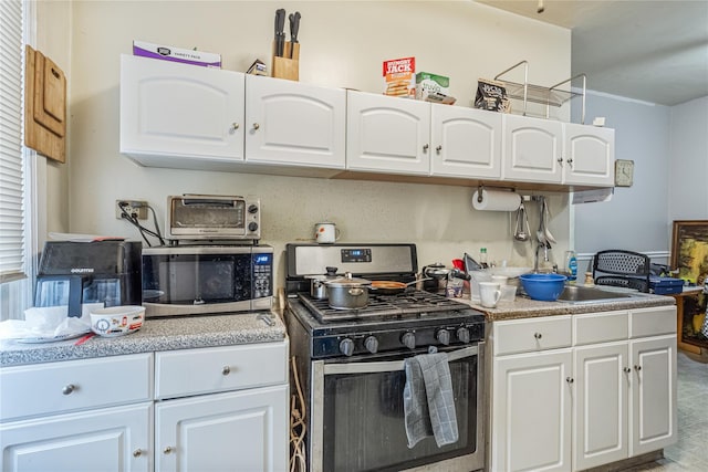 1816 21st Dr, Astoria, NY 11105 - kitchen featuring a toaster, white cabinets, appliances with stainless steel finishes, and a sink