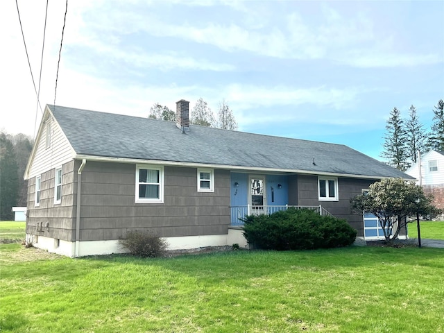 view of front of house with a porch, a chimney, a front lawn, and roof with shingles
