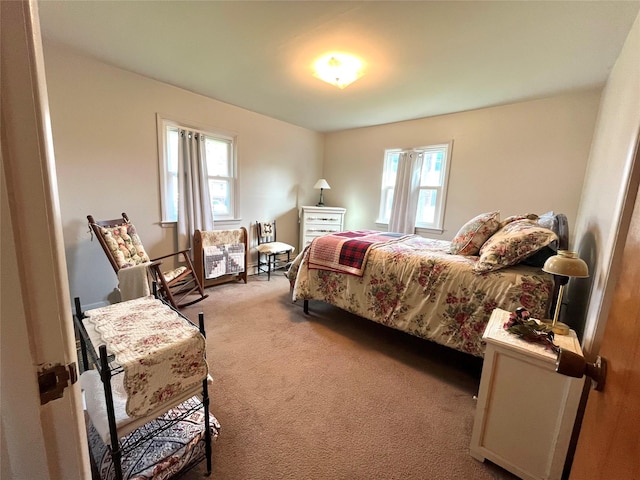 bedroom featuring light colored carpet and multiple windows