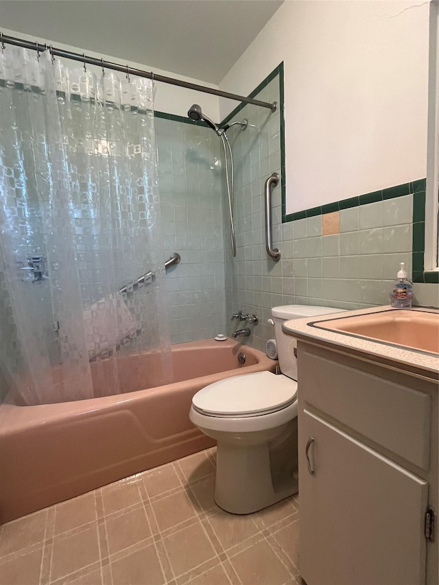 full bath featuring tile patterned floors, toilet, vanity, tile walls, and shower / bath combo