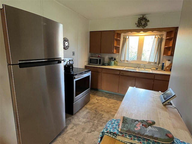 kitchen featuring stainless steel appliances, open shelves, light countertops, visible vents, and a sink