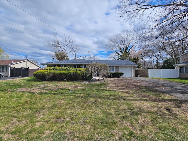 single story home featuring driveway, fence, a front lawn, and a garage