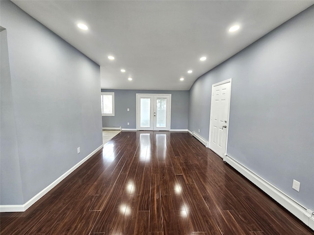 unfurnished living room with a baseboard heating unit, recessed lighting, and wood finished floors