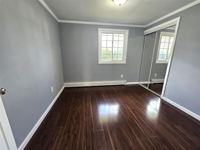 unfurnished bedroom featuring wood finished floors, ornamental molding, baseboard heating, and baseboards