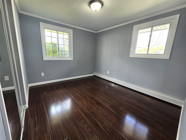 empty room with crown molding, dark wood-style flooring, baseboard heating, and baseboards