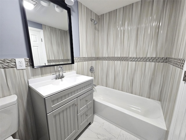 full bath with toilet, marble finish floor, washtub / shower combination, and vanity