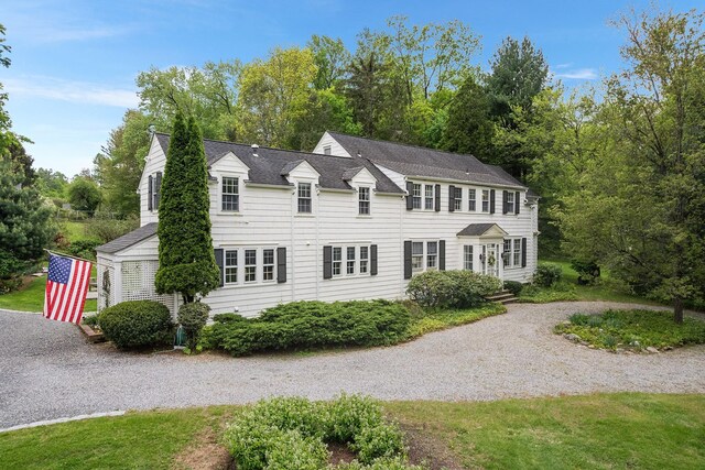 colonial-style house featuring gravel driveway