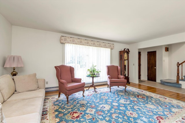 living area with a baseboard radiator, stairs, wood finished floors, and baseboard heating
