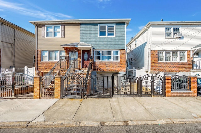 view of property with a gate, brick siding, and a fenced front yard