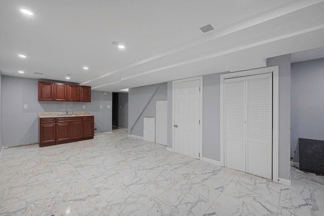 kitchen with baseboards, recessed lighting, marble finish floor, reddish brown cabinets, and light countertops