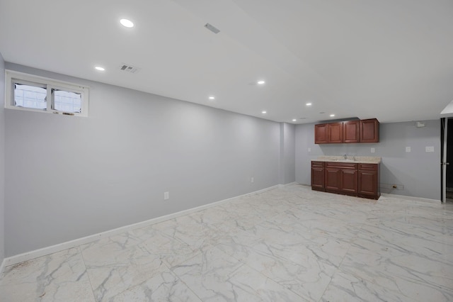 basement featuring marble finish floor, baseboards, visible vents, and recessed lighting