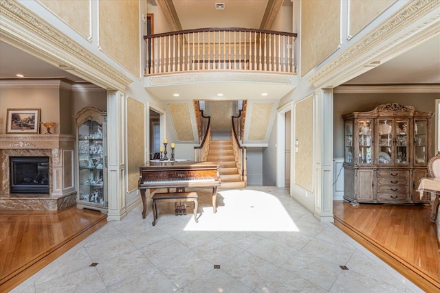 entryway featuring baseboards, a high ceiling, a fireplace, and stairway