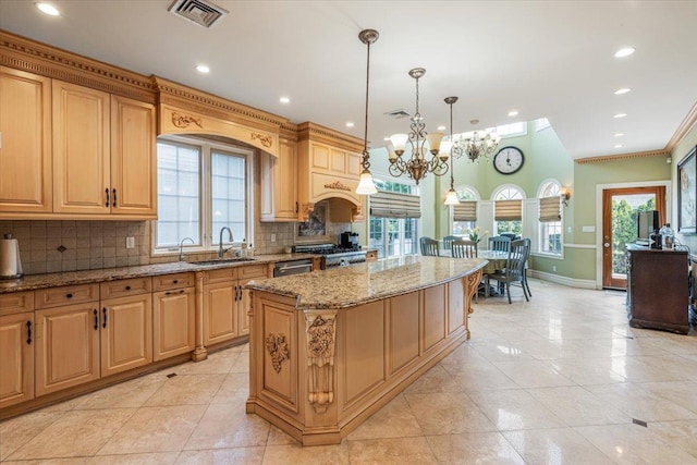 kitchen featuring visible vents, a center island, tasteful backsplash, light stone countertops, and a chandelier