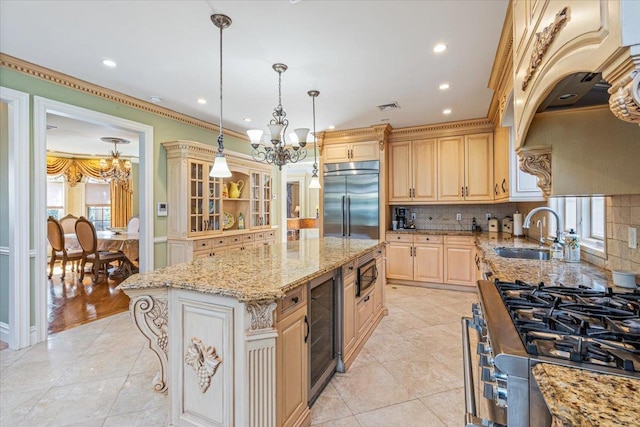 kitchen with decorative backsplash, built in appliances, beverage cooler, a sink, and a notable chandelier