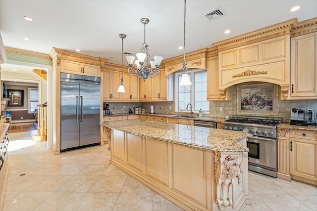 kitchen featuring visible vents, high end appliances, light stone countertops, a sink, and an inviting chandelier