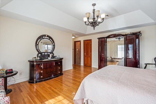 bedroom with baseboards, a chandelier, multiple windows, and light wood-type flooring