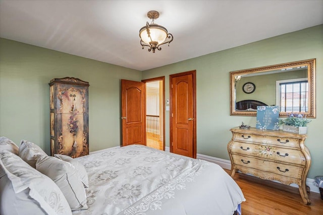bedroom with baseboards and wood finished floors