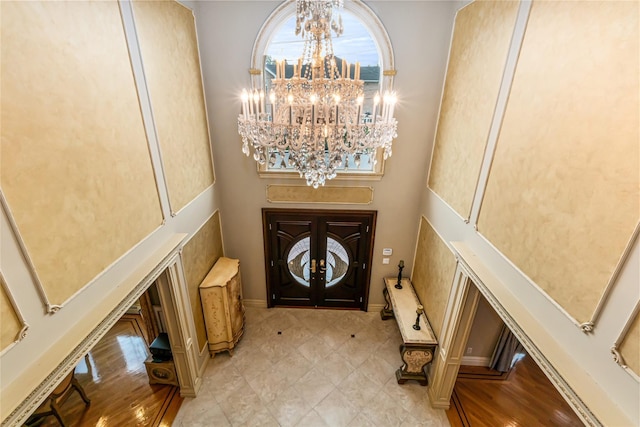 entryway featuring a chandelier and a towering ceiling