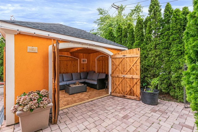 view of patio with an outdoor living space and a gate
