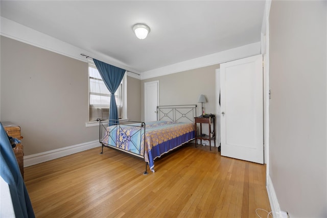 bedroom with baseboards and light wood-style flooring