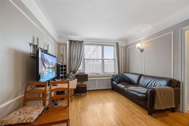 living area with hardwood / wood-style floors and radiator heating unit