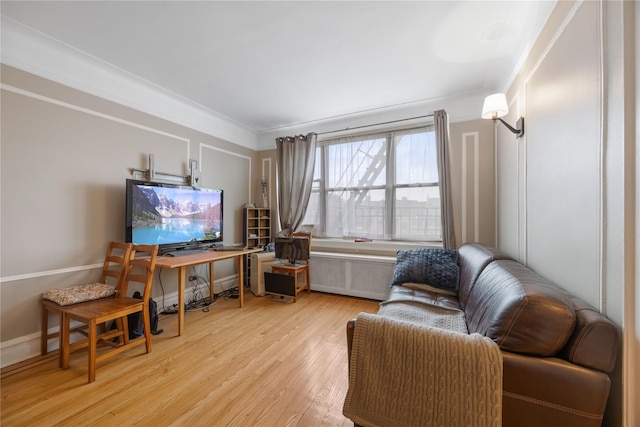 living room featuring crown molding, radiator heating unit, and wood finished floors