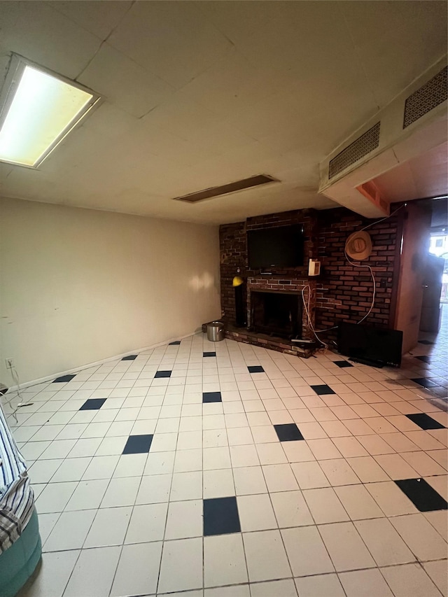 unfurnished living room featuring visible vents, a brick fireplace, and light tile patterned flooring