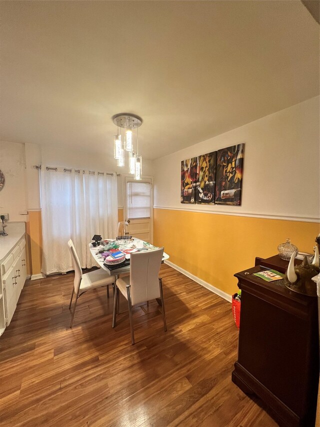 dining room with a chandelier, wood finished floors, and baseboards