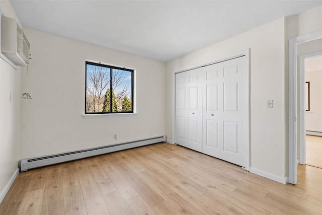 5 Fitzherbert Mews, Middletown, NY 10940 - unfurnished bedroom with baseboards, a wall mounted AC, light wood-type flooring, and a baseboard radiator