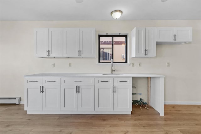 5 Fitzherbert Mews, Middletown, NY 10940 - kitchen with a sink, white cabinetry, light wood finished floors, and baseboard heating