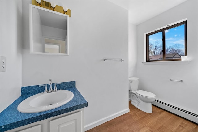 5 Fitzherbert Mews, Middletown, NY 10940 - half bath with vanity, wood finished floors, toilet, baseboards, and a baseboard heating unit