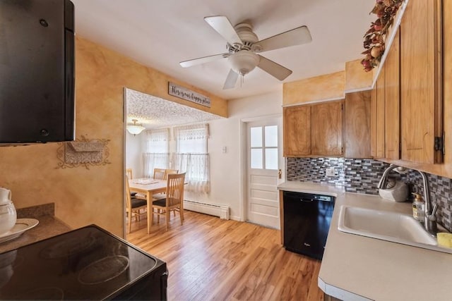 kitchen featuring light wood finished floors, light countertops, a ceiling fan, black appliances, and a baseboard radiator