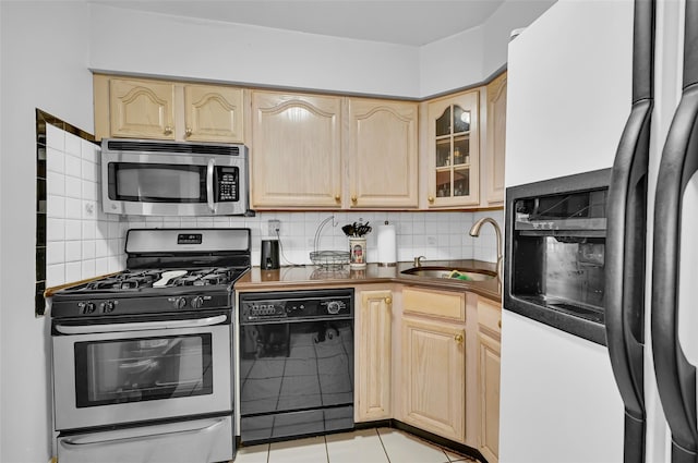 4415 Mundy Ln, Bronx, NY 10466 - kitchen with appliances with stainless steel finishes, light brown cabinets, a sink, dark countertops, and backsplash