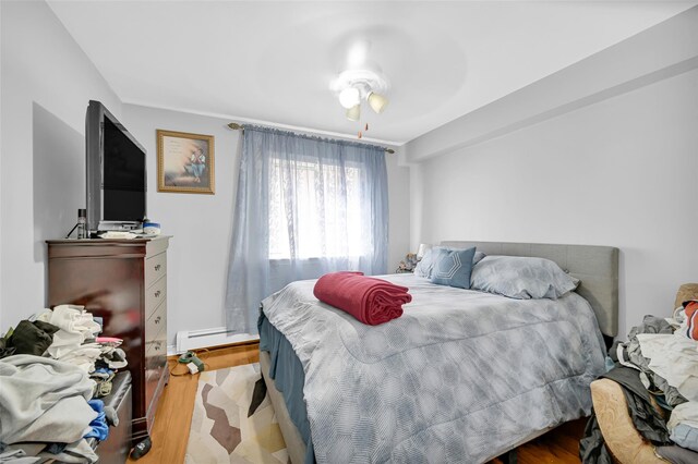 4415 Mundy Ln, Bronx, NY 10466 - bedroom with a baseboard heating unit and wood finished floors