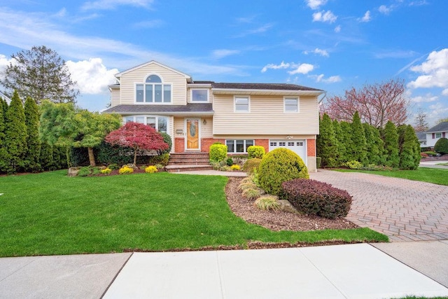 view of front of property featuring an attached garage, a front yard, and decorative driveway