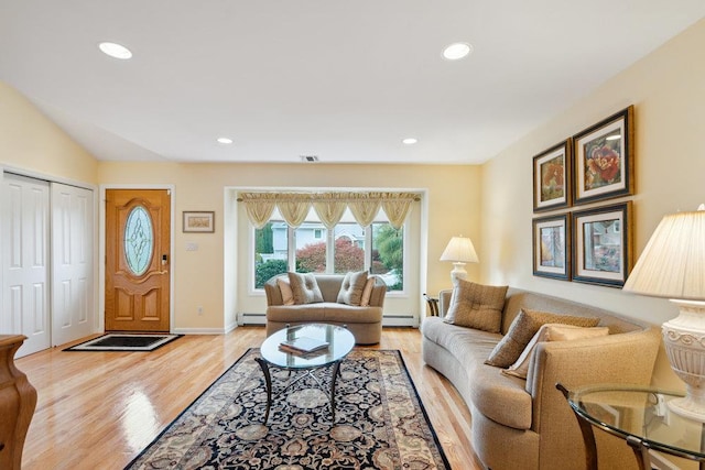living area with baseboard heating, visible vents, recessed lighting, and light wood-style flooring