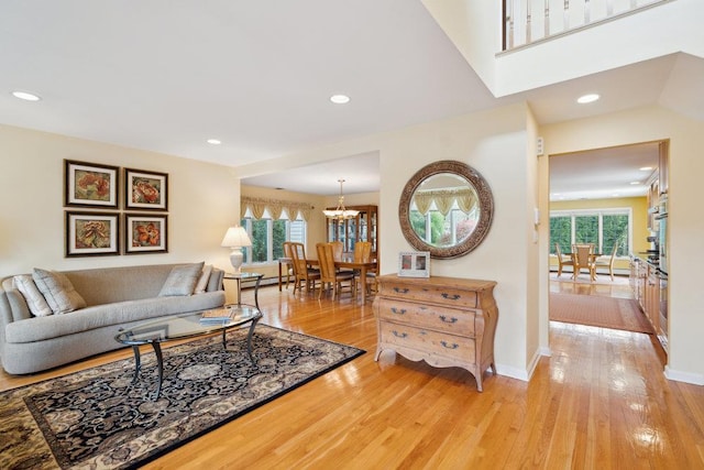 living area with a notable chandelier, recessed lighting, a healthy amount of sunlight, and light wood-style flooring